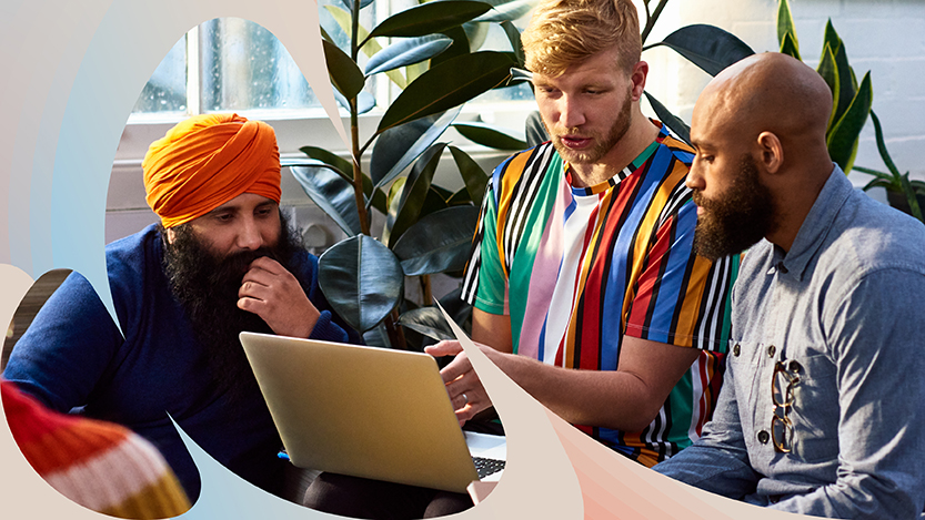 Three colleagues talking around a laptop computer.